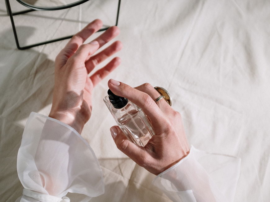 Frau sprüht sich Parfum aus