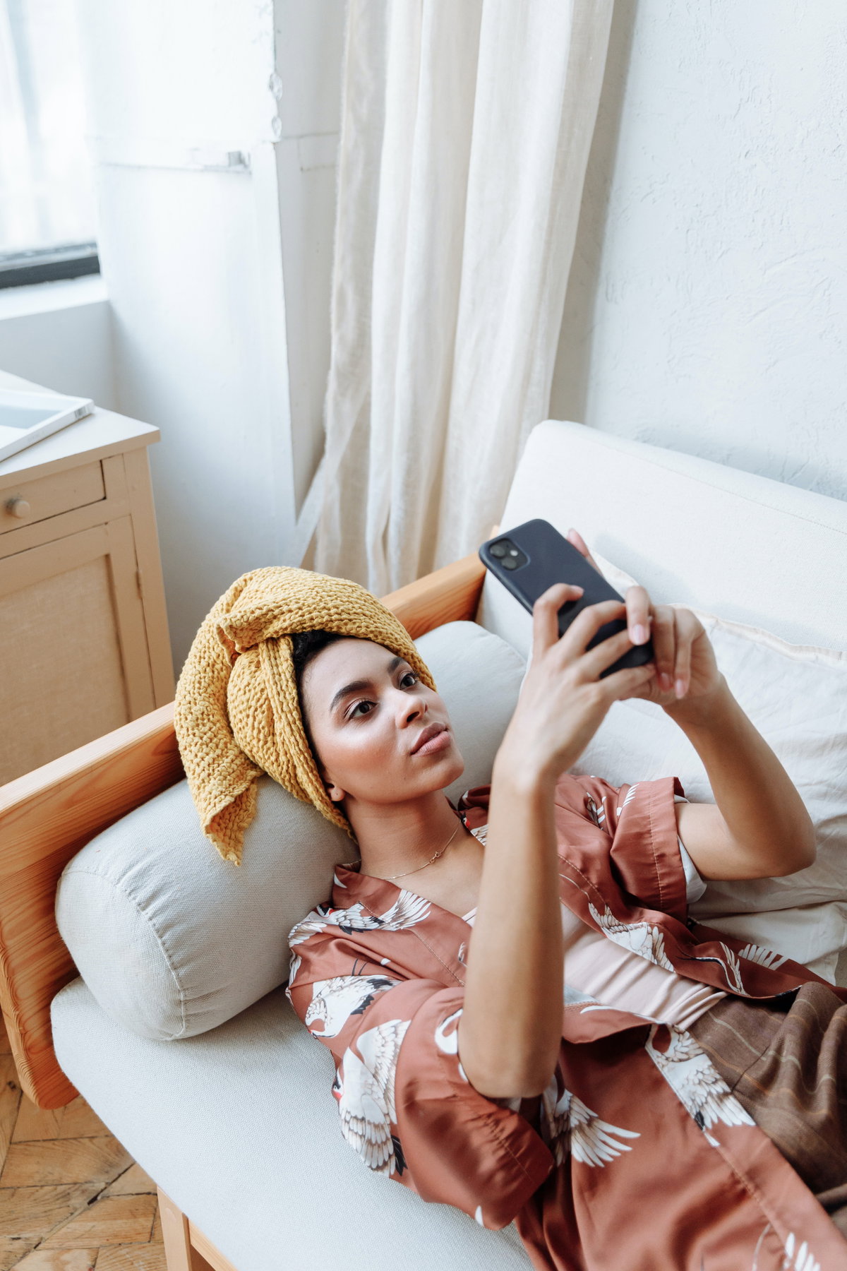 Frau mit Handy auf Sofa