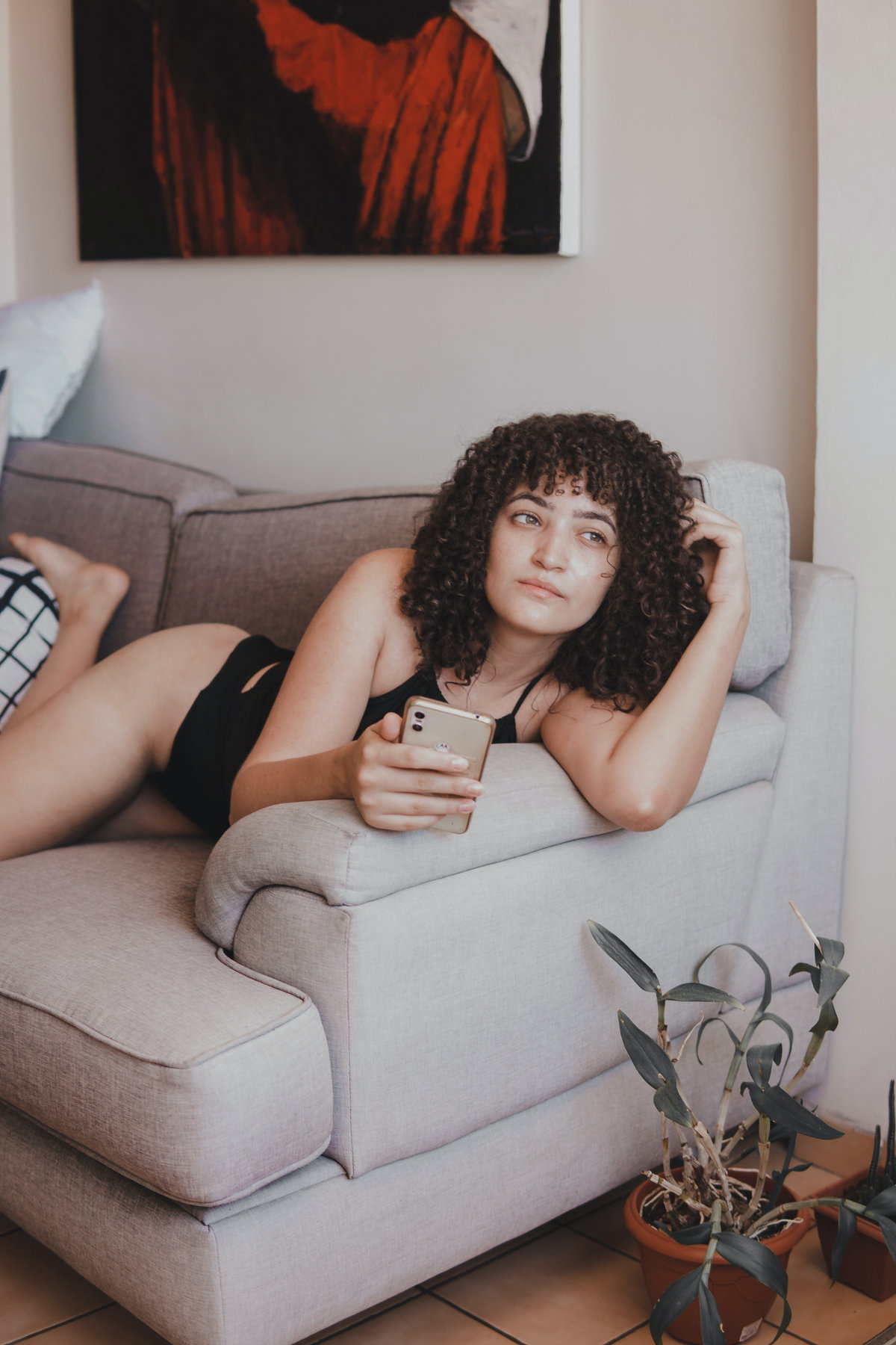Frau mit Handy auf Sofa