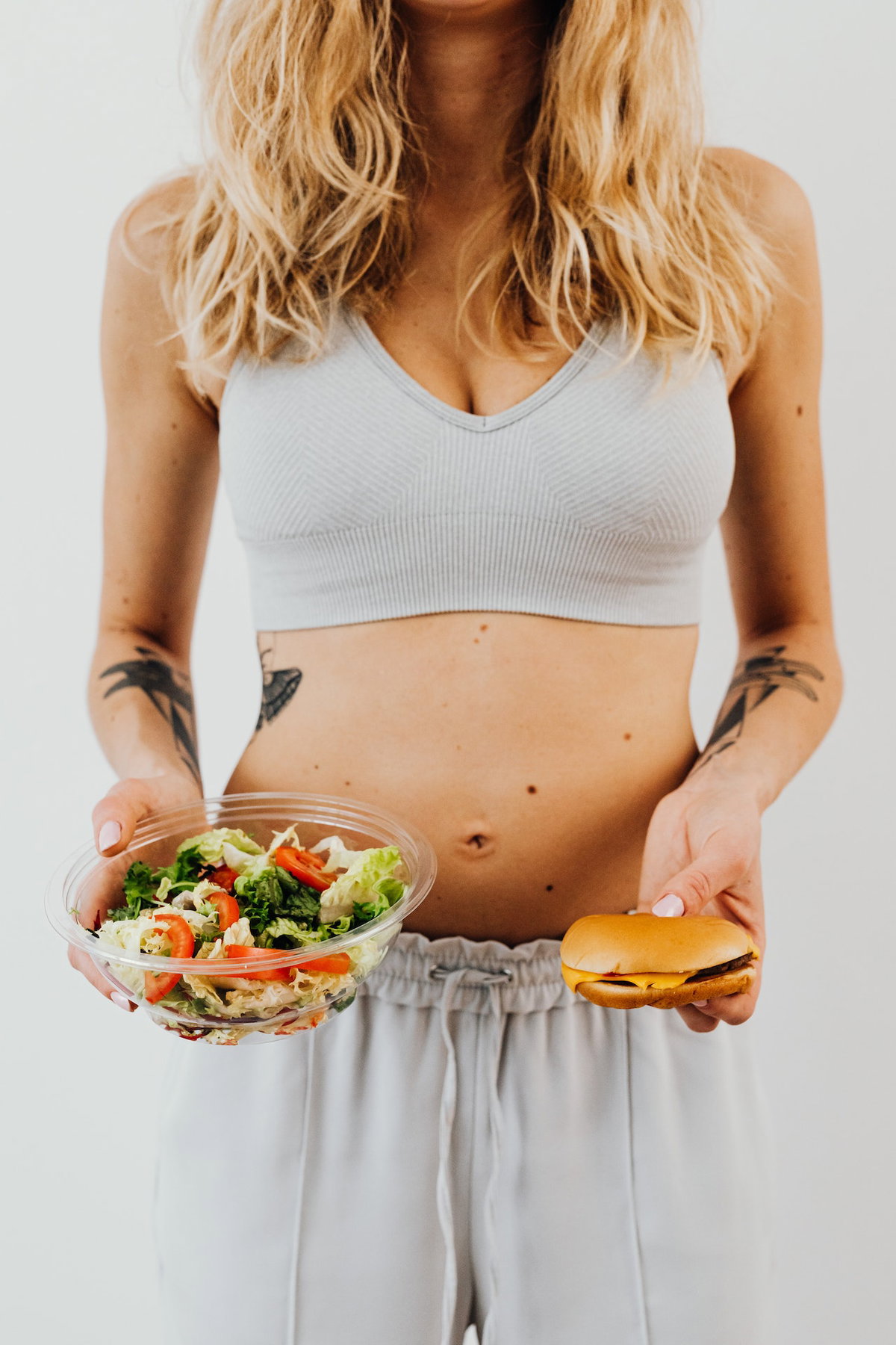 Frau mit Salat und Burger