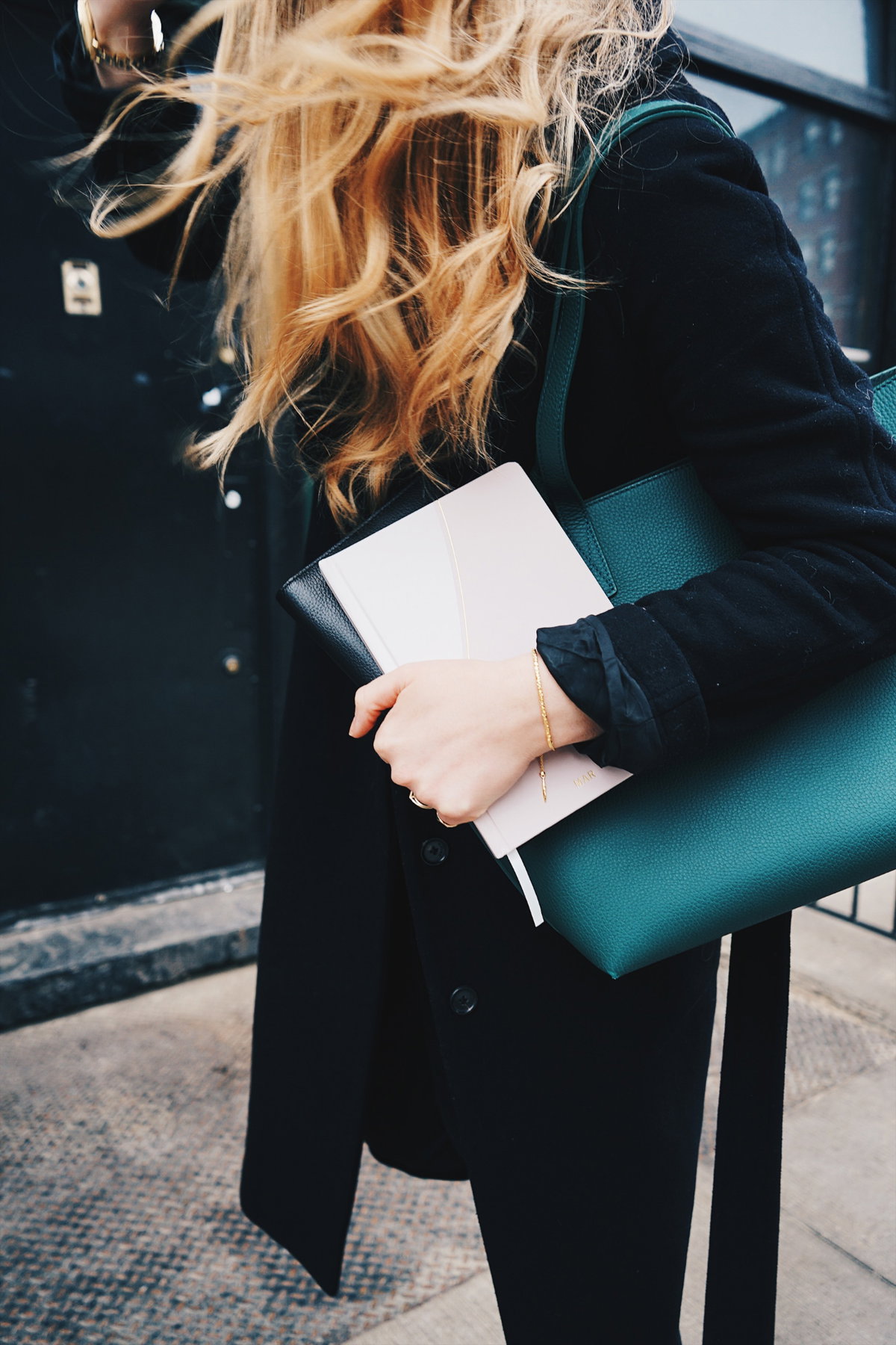 Frau trägt Notizbuch in der hand Tasche blonde Haare