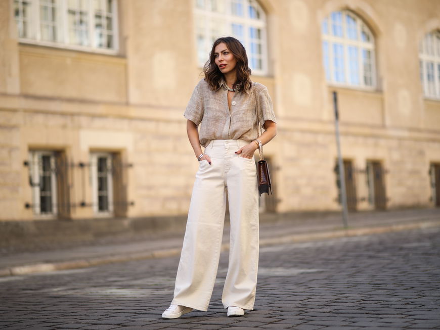 Frau trägt beige Hose und Sneaker