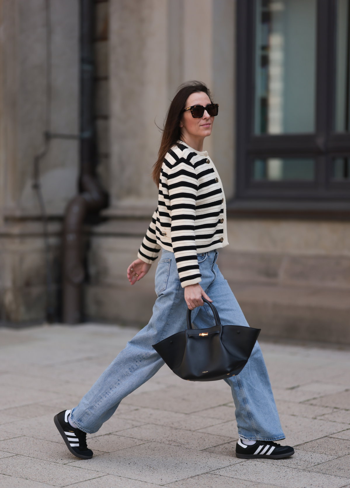 Frau trägt Adidas Sneaker und Jeans