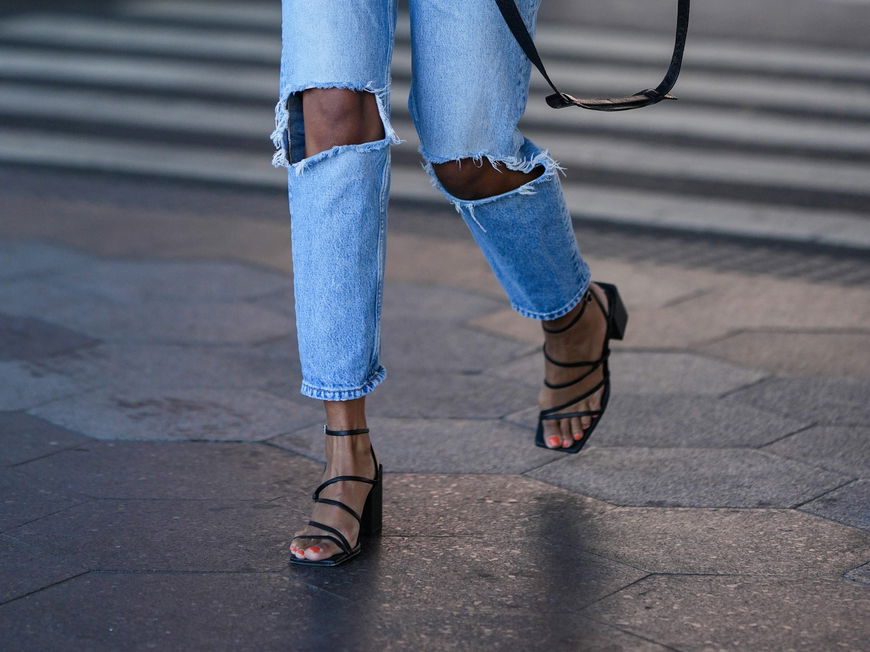 Frau trägt schwarze Sandalen