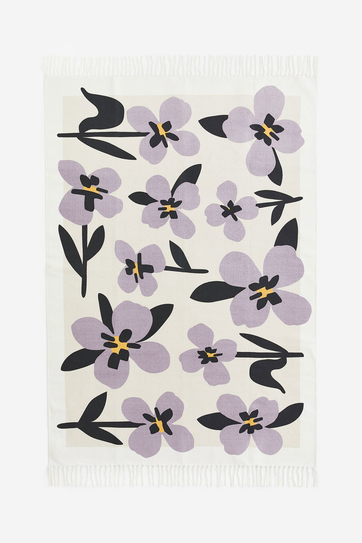 Gemusterter Flachgewebeteppich von H&M Home Home mit großflächigen Blumen.