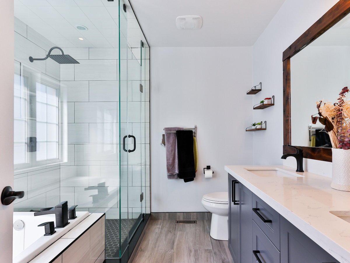 großes Badezimmer mit Spiegel, Waschbecken, Toilette, Dusche und Badewanne