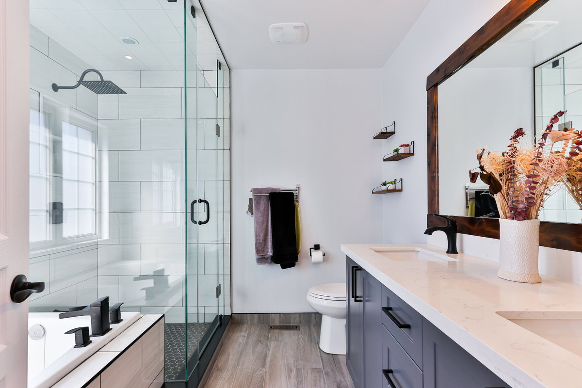 großes Badezimmer mit Spiegel, Waschbecken, Toilette, Dusche und Badewanne