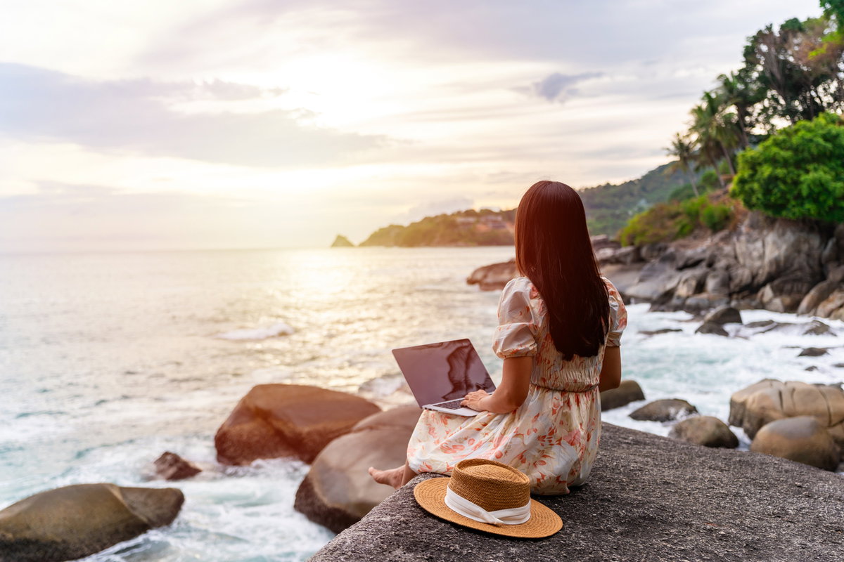 Frau mit Laptop am Strand