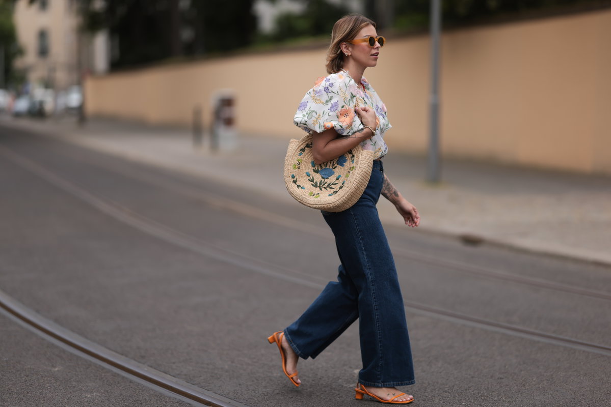 Frau trägt eine Blümchen-Bluse und Jeans