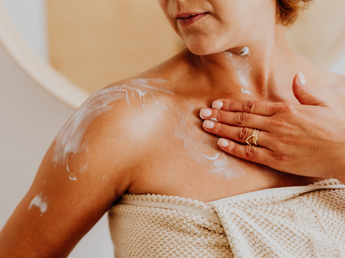 Frau trägt Bodylotion auf