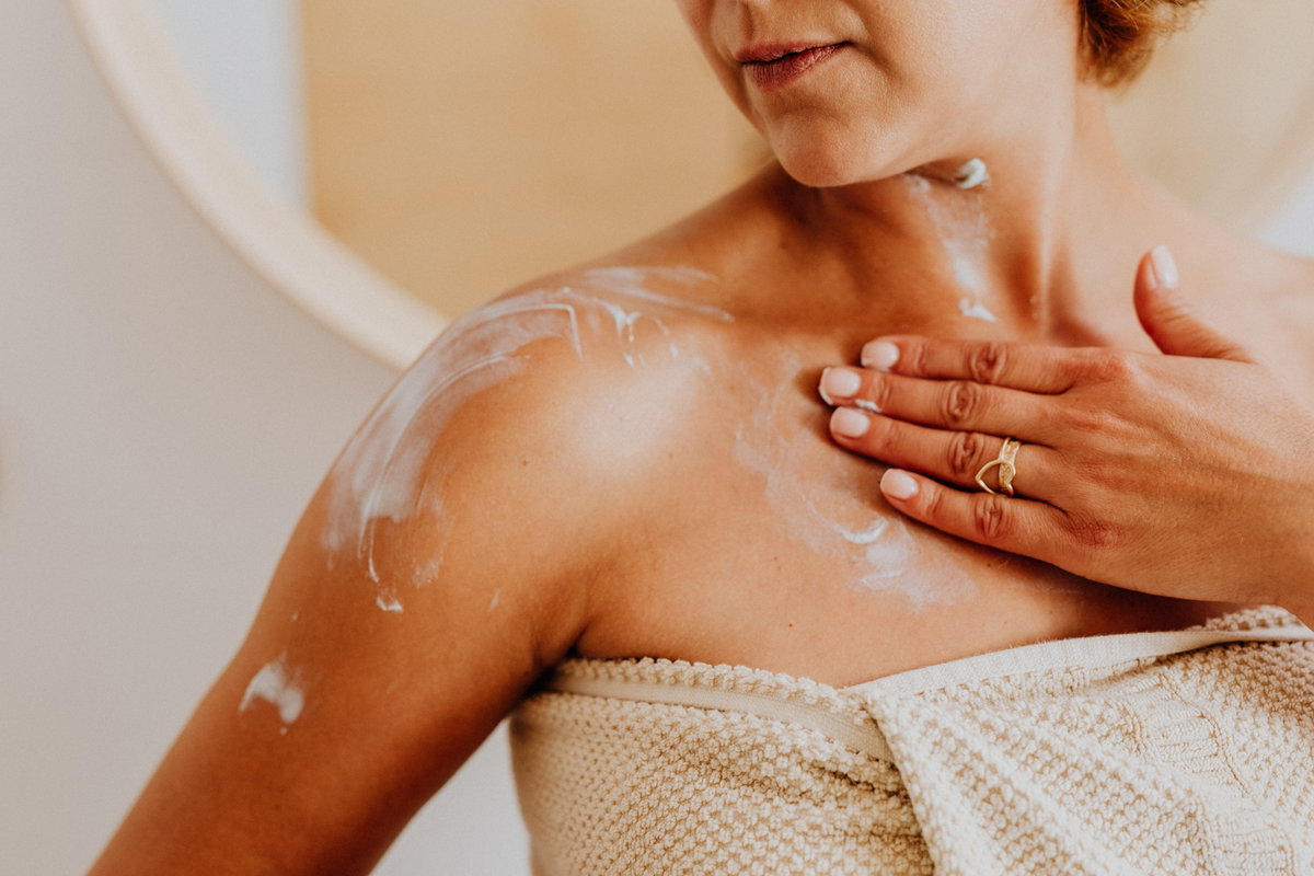 Frau trägt Bodylotion auf