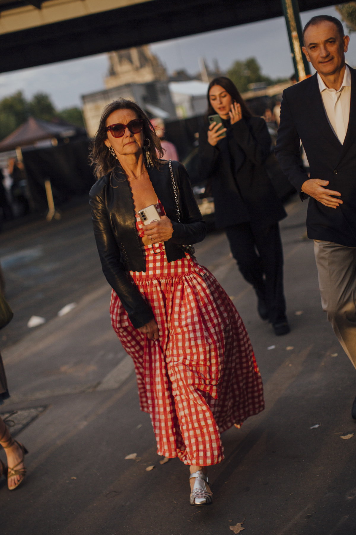 Frau auf der paris fashion week trägt rotes Maxikleid und schwarze Jacke Streetstyle