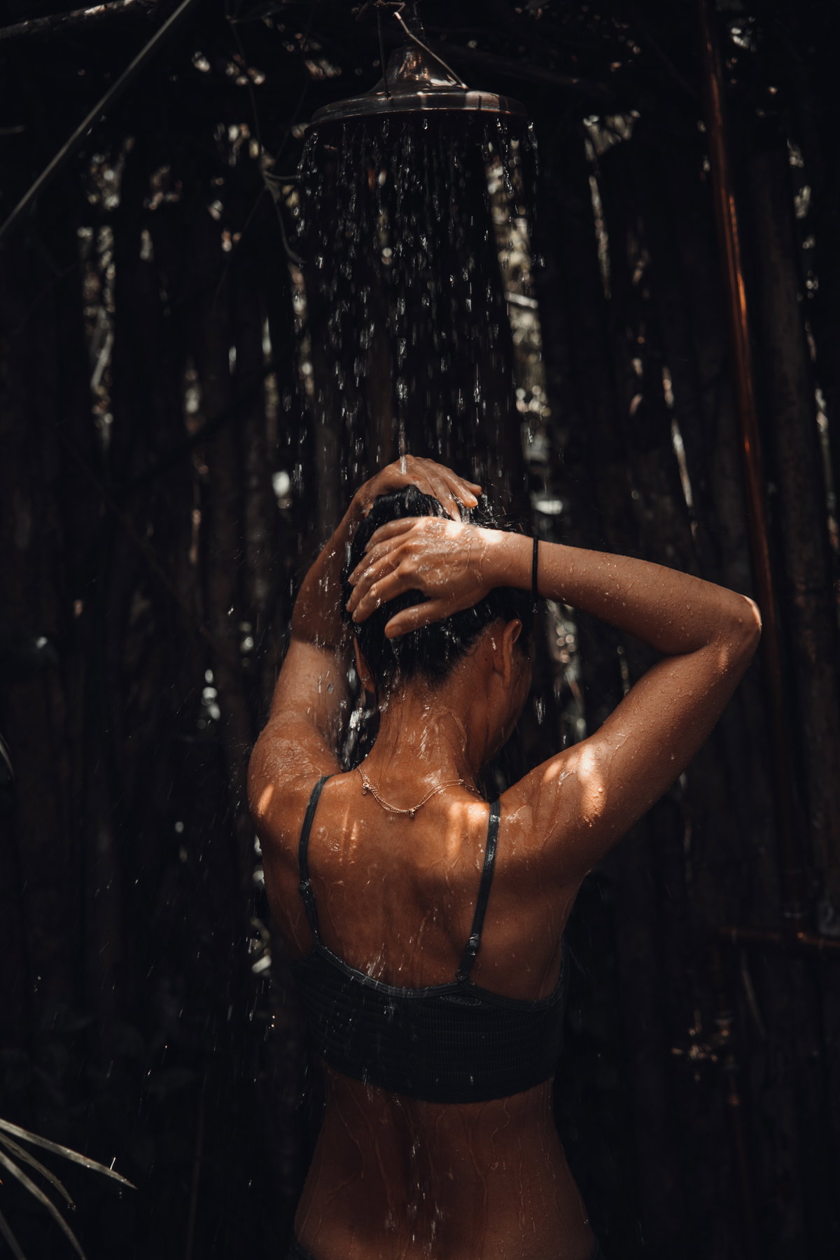 Frau im Bikini unter der Dusche