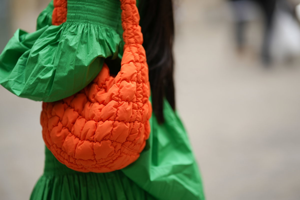 Eine Frau trägt eine große Tasche von COS
