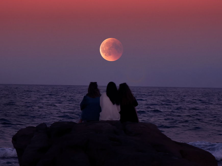 Frauen sitzen am Meer