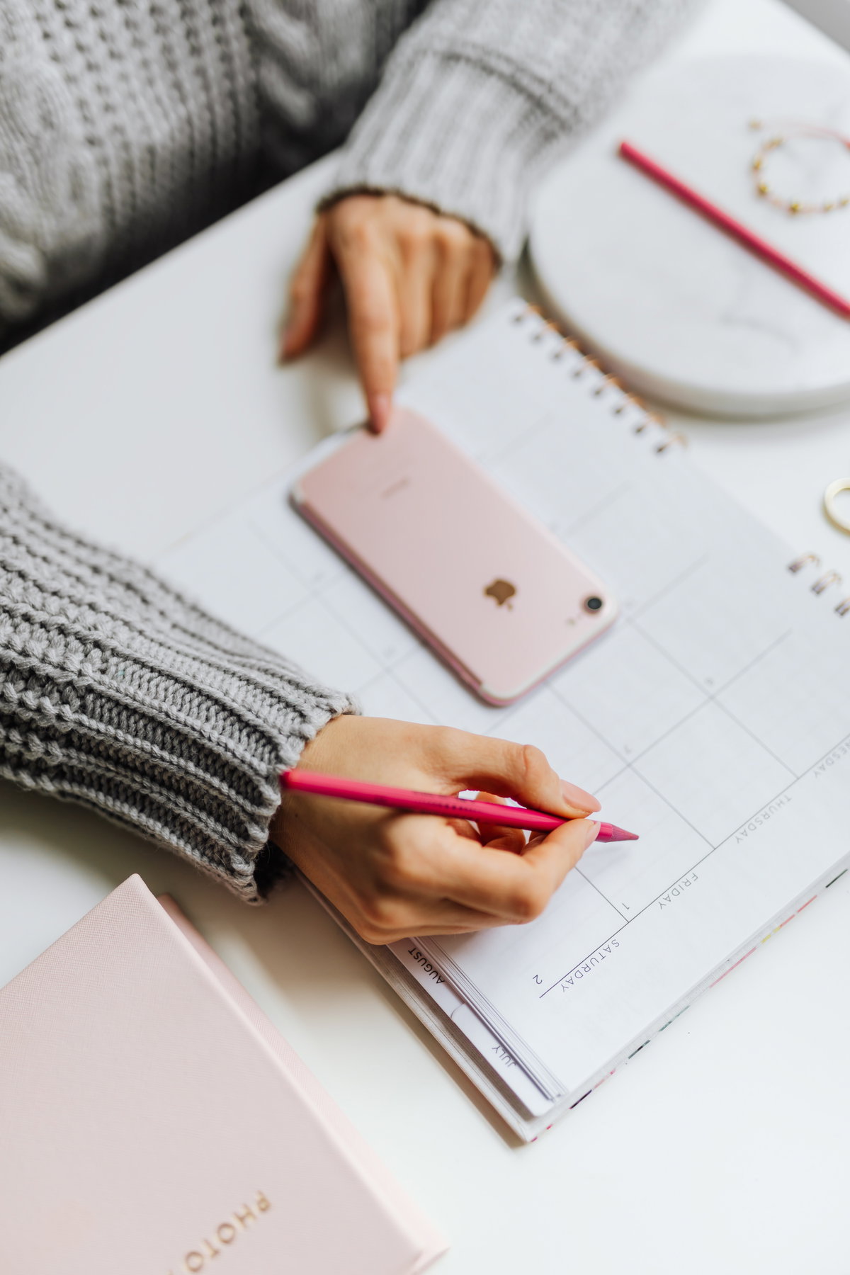 Frau schreibt mit einem Stift etwas in ihren Kalender