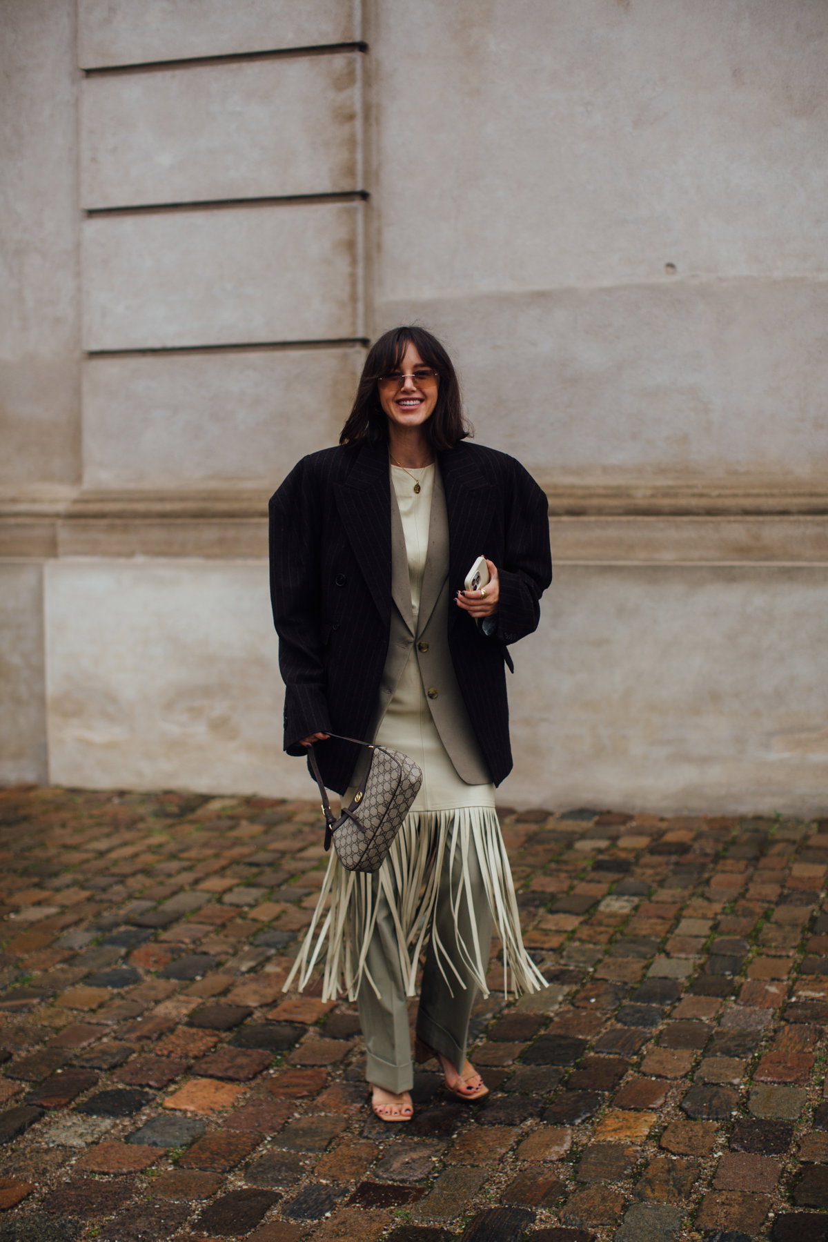 Frau auf Copenhagen Fashion Week trägt Haare mit Pony und Fashion Look mit Blazer