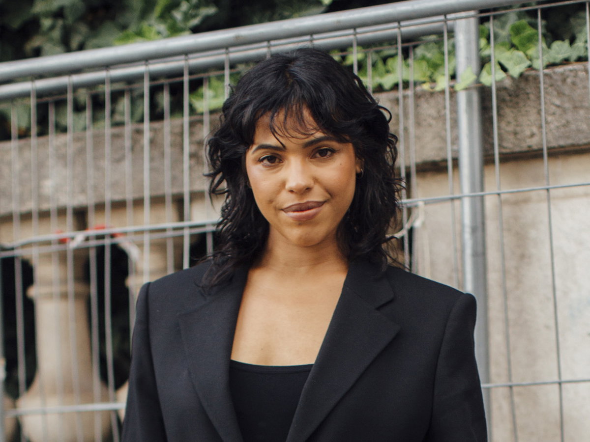 Paris Streetstyle Frau trägt angesagten Look und Locken im Haar plus pony