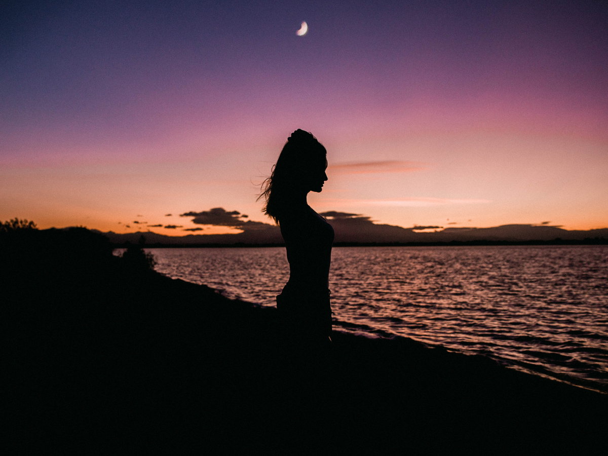 Frau mit Mond am Strand
