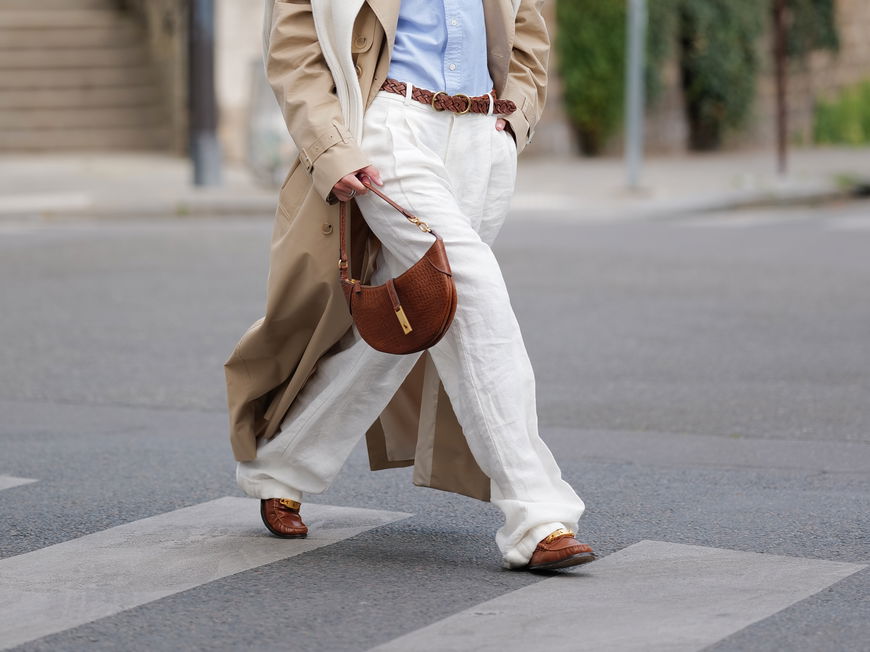 Eine Frau trägt einen Trenchcoat und Loafer