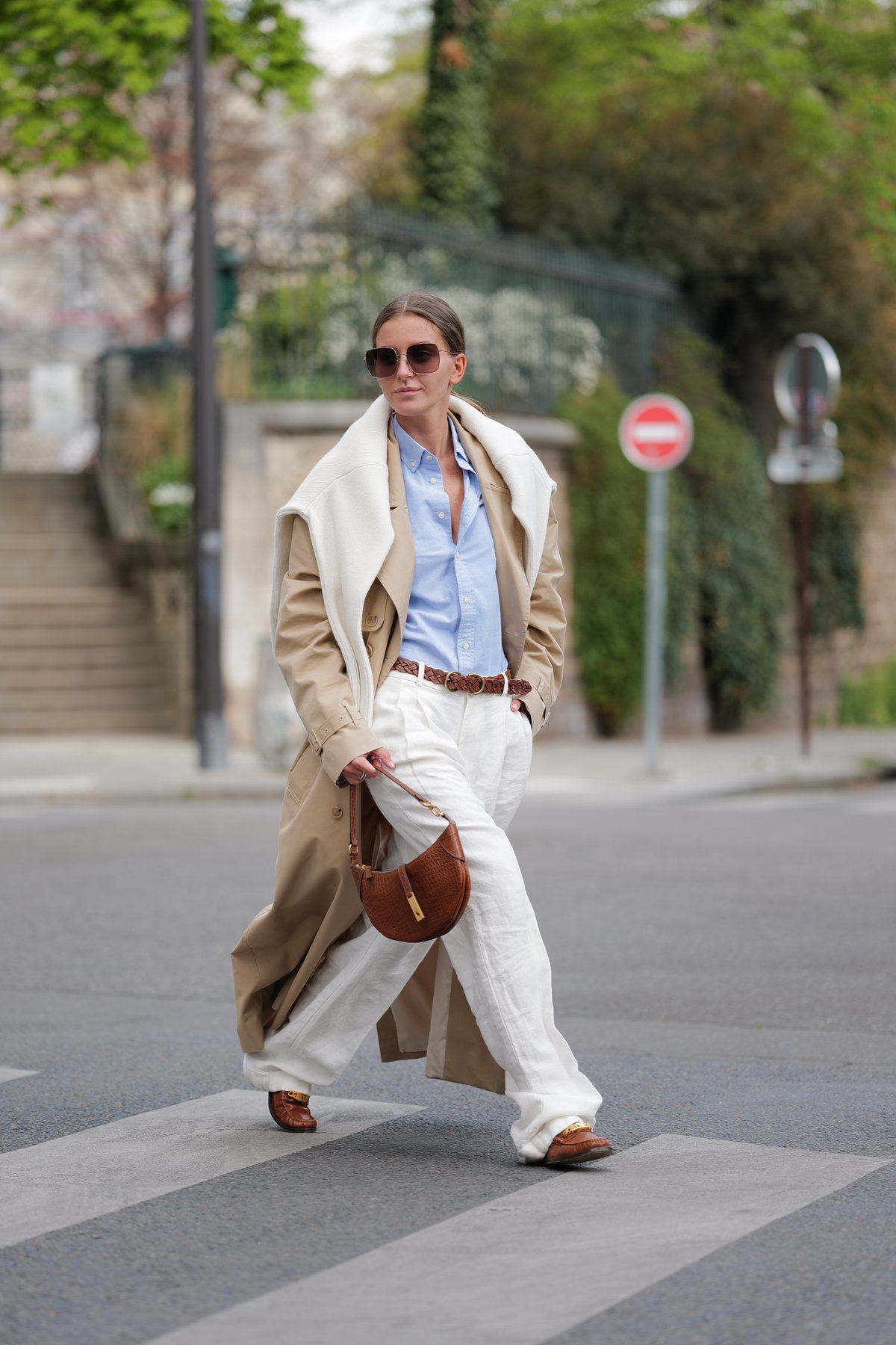 Eine Frau trägt einen Trenchcoat und Loafer