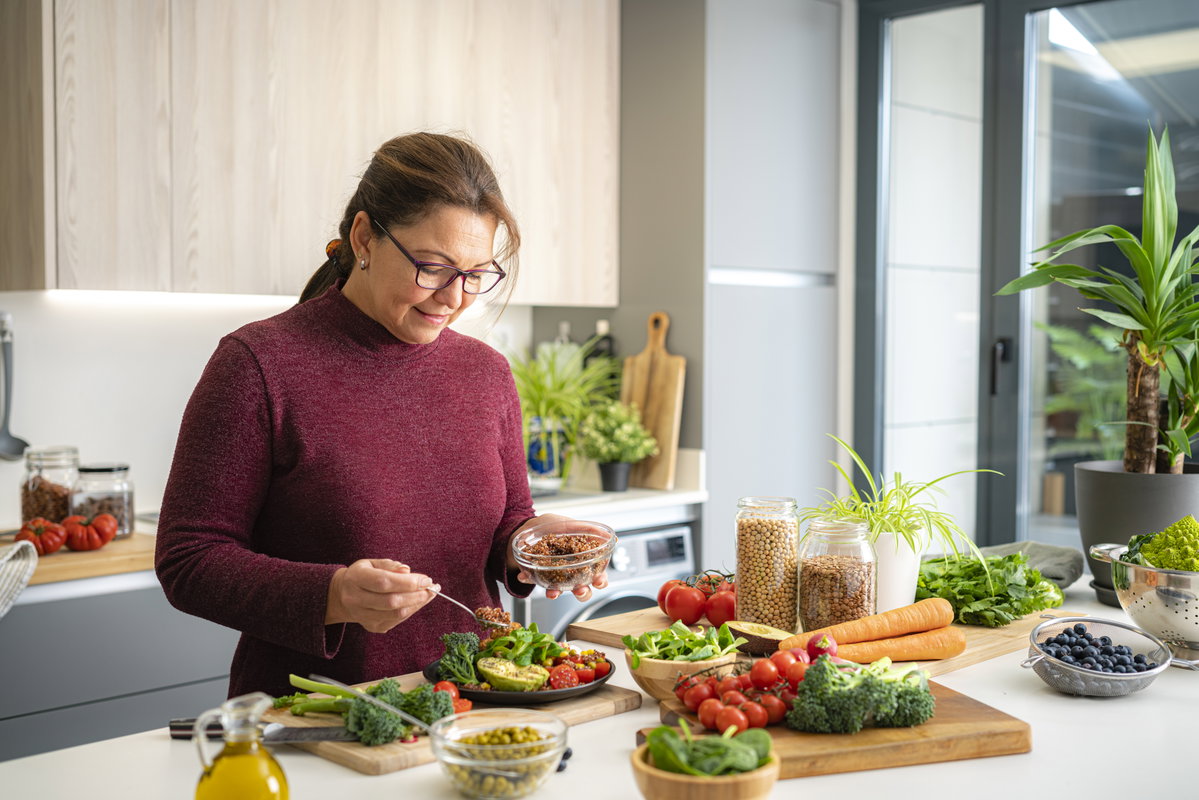 Frau bereitet in der Küche einen Salat zu