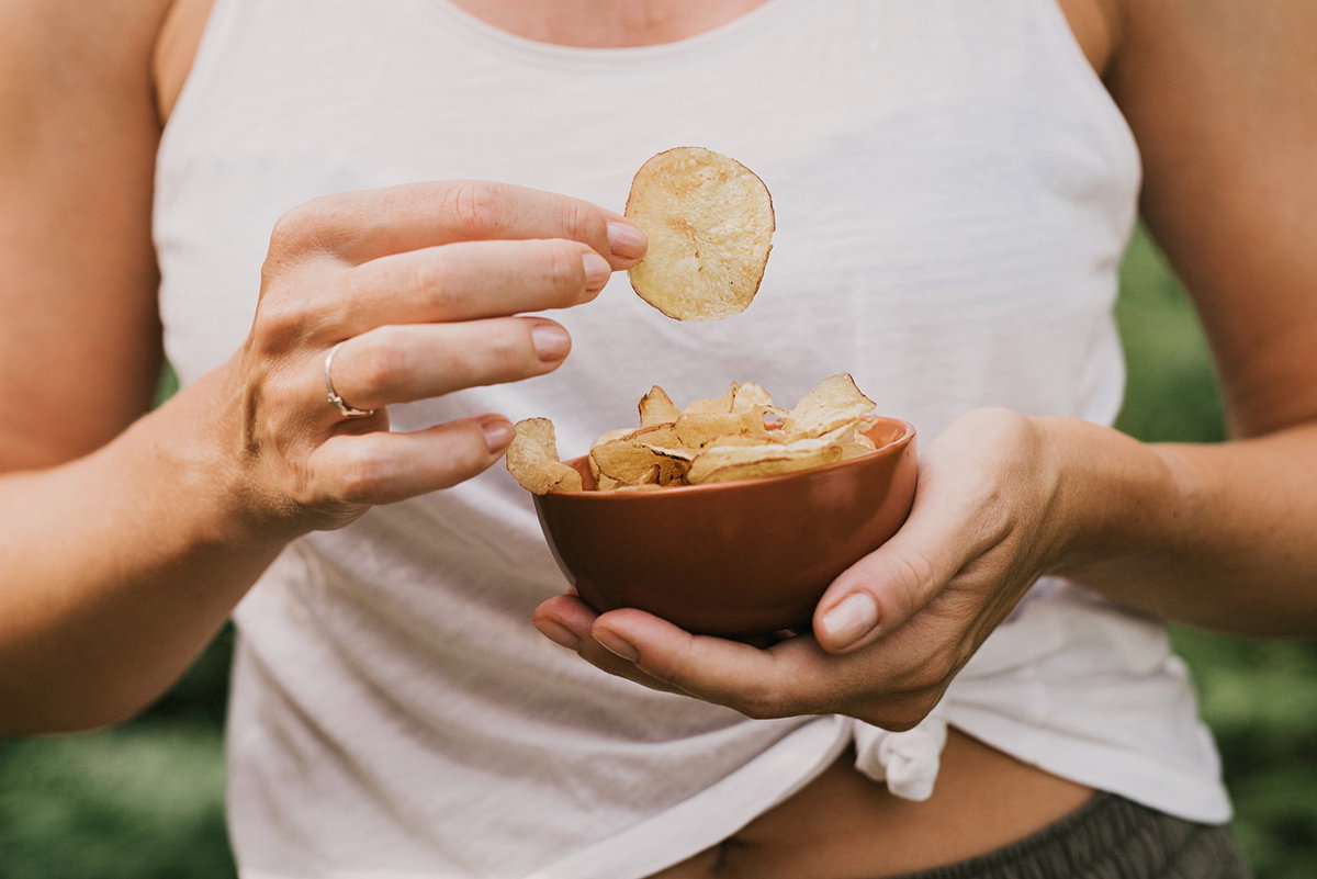 Frau isst Kartoffelchips