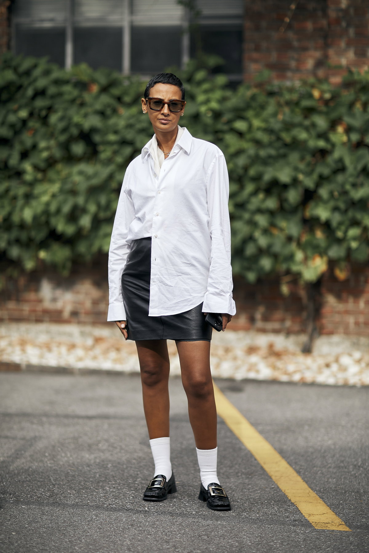 Mailand Fashion Week Streetstyle Frau trägt kurze schwarze Haare und angesagten Look