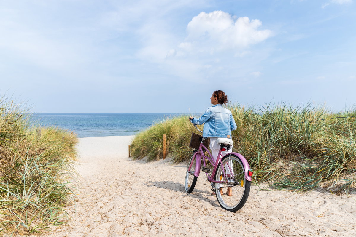 Frau auf Fahhrad an einem Strand in Ostdeutschland