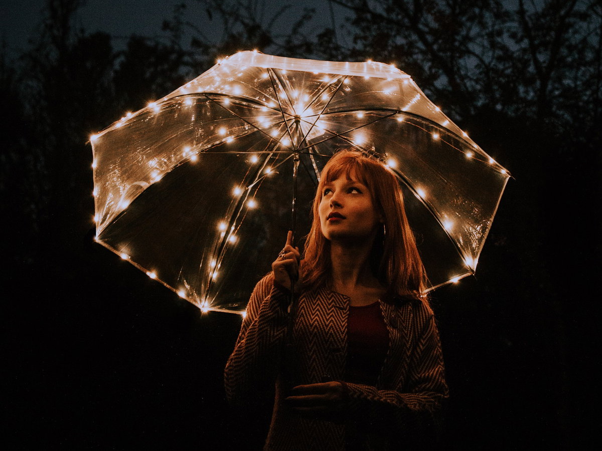 Sternzeichen Frau in der Nacht mit leuchtendem Schirm