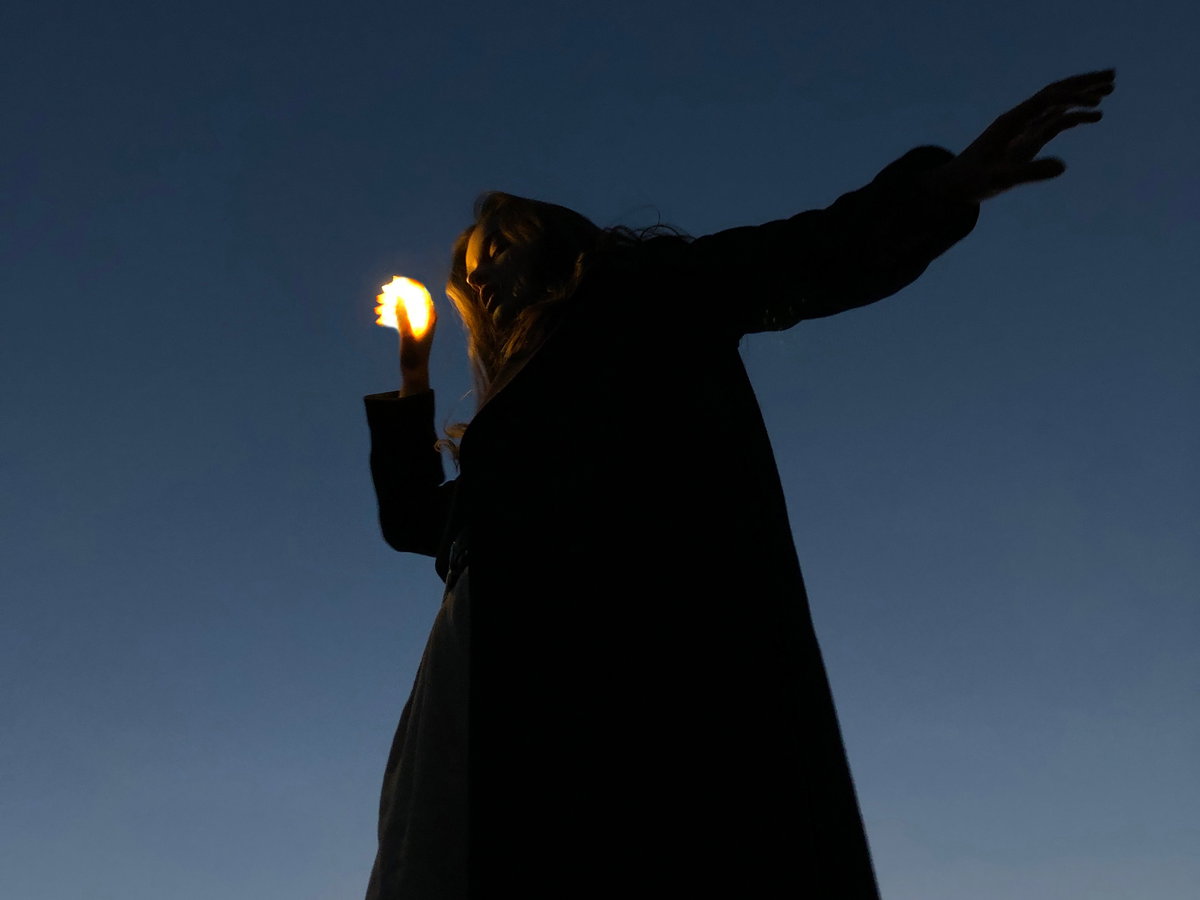 Frau hält eine kleine Lichtkugel in der Hand