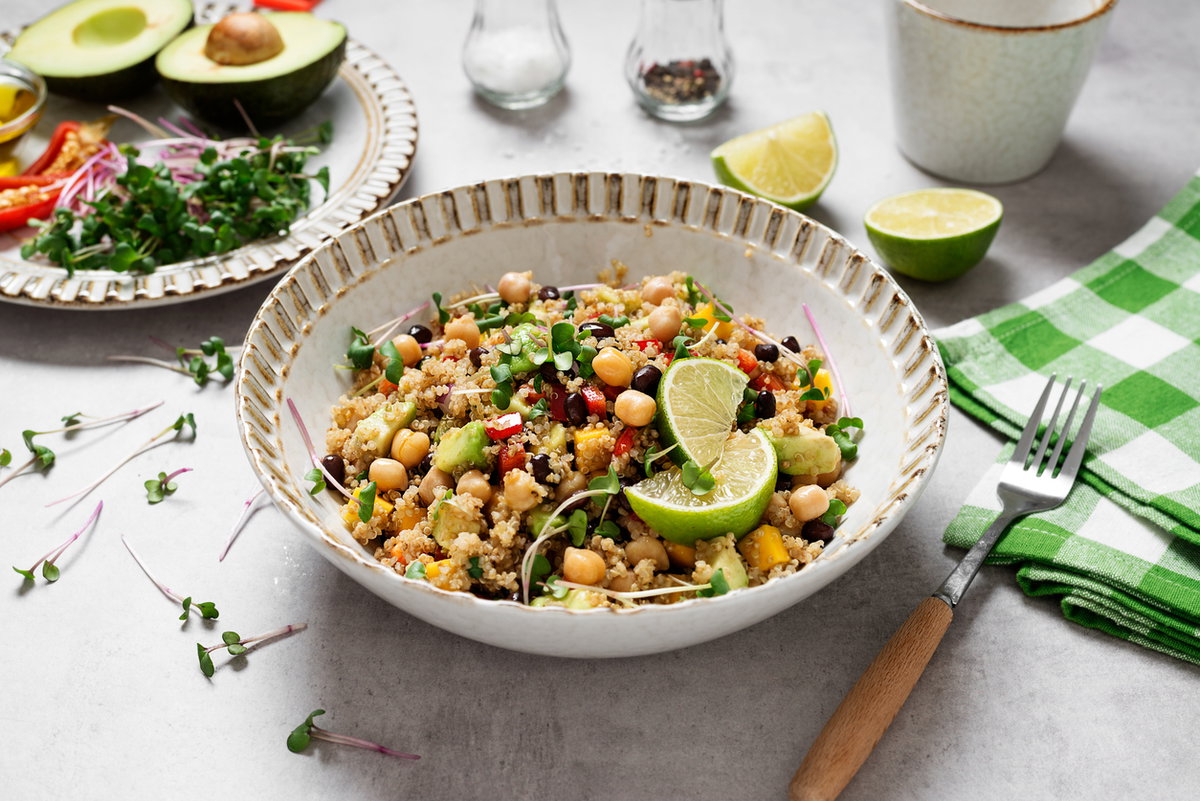 Ein Teller Quinoa-Salat mit Kichererbsen und Limette steht auf einem Tisch