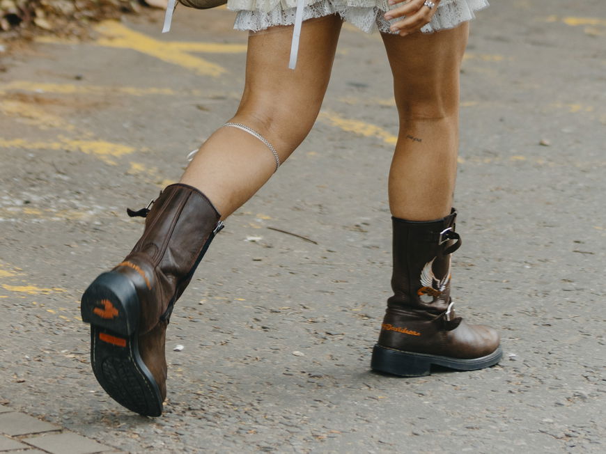 Frau trägt auf Londoner Fashion Week braunen Biker Boot