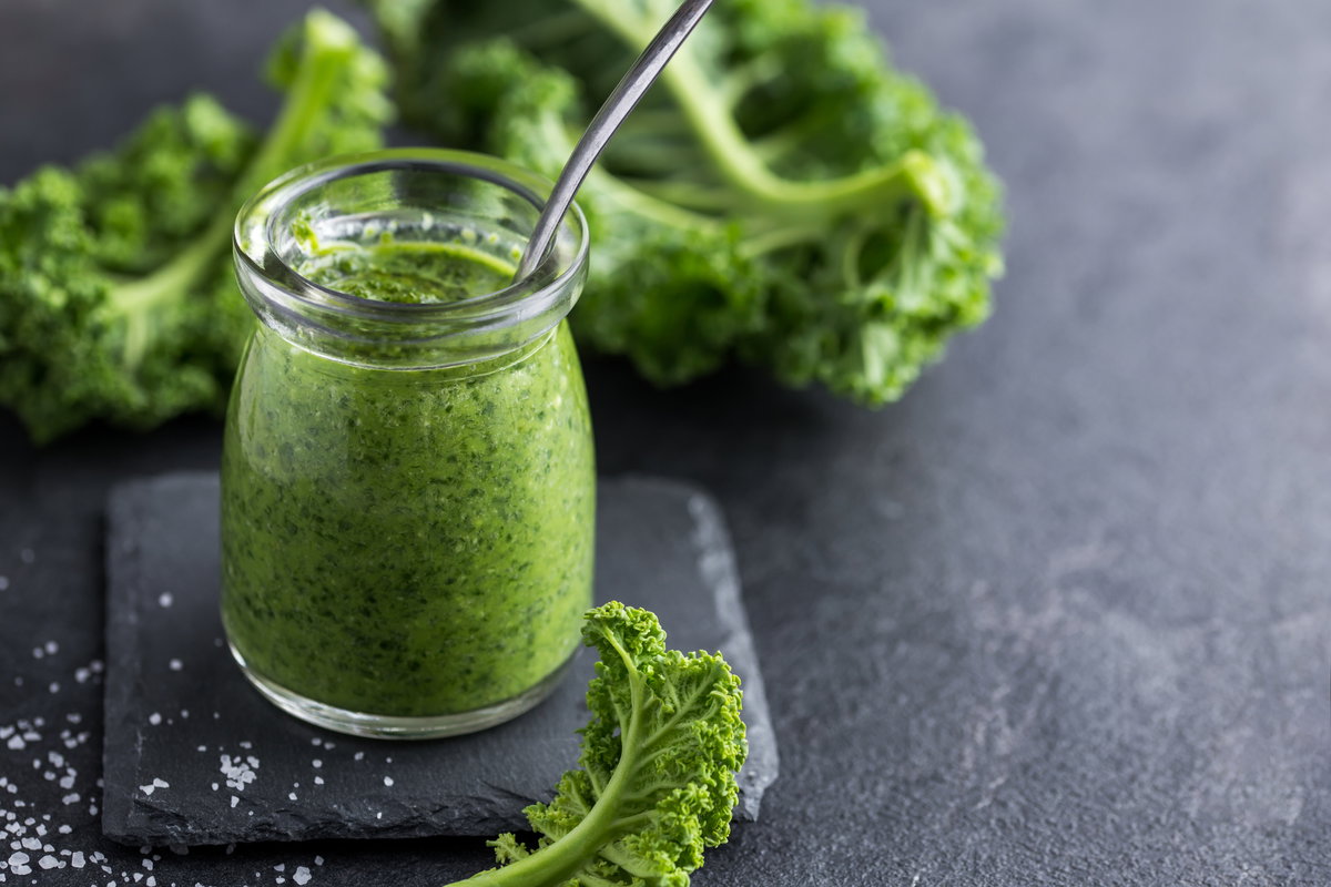 Grünkohl-Pesto im Glas auf einem grauen Tisch