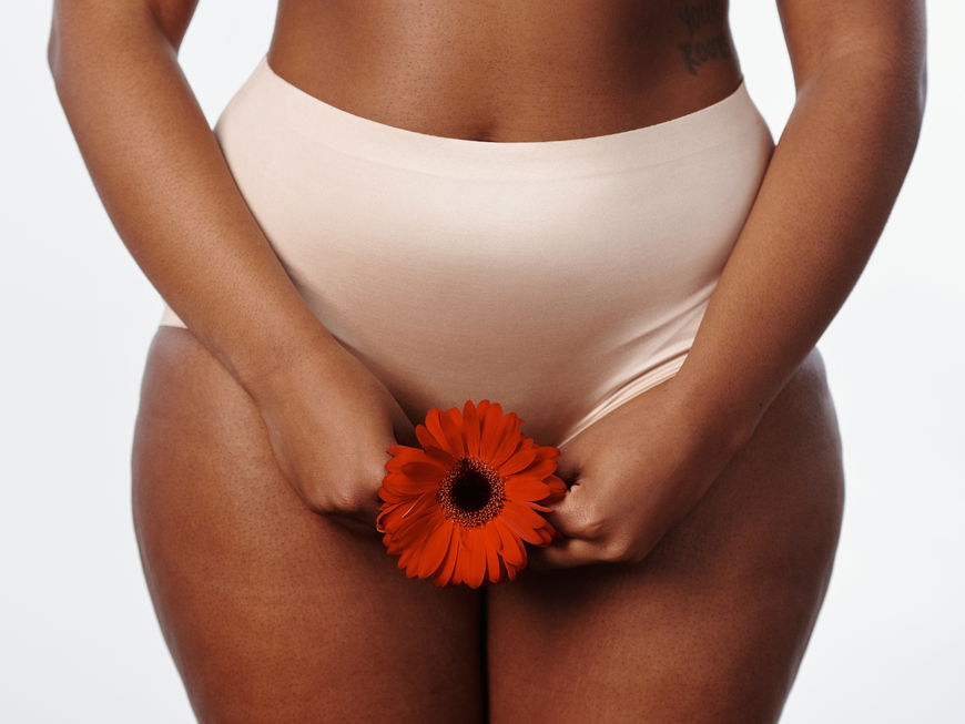 Frau mit Blume vor Intimbereich
