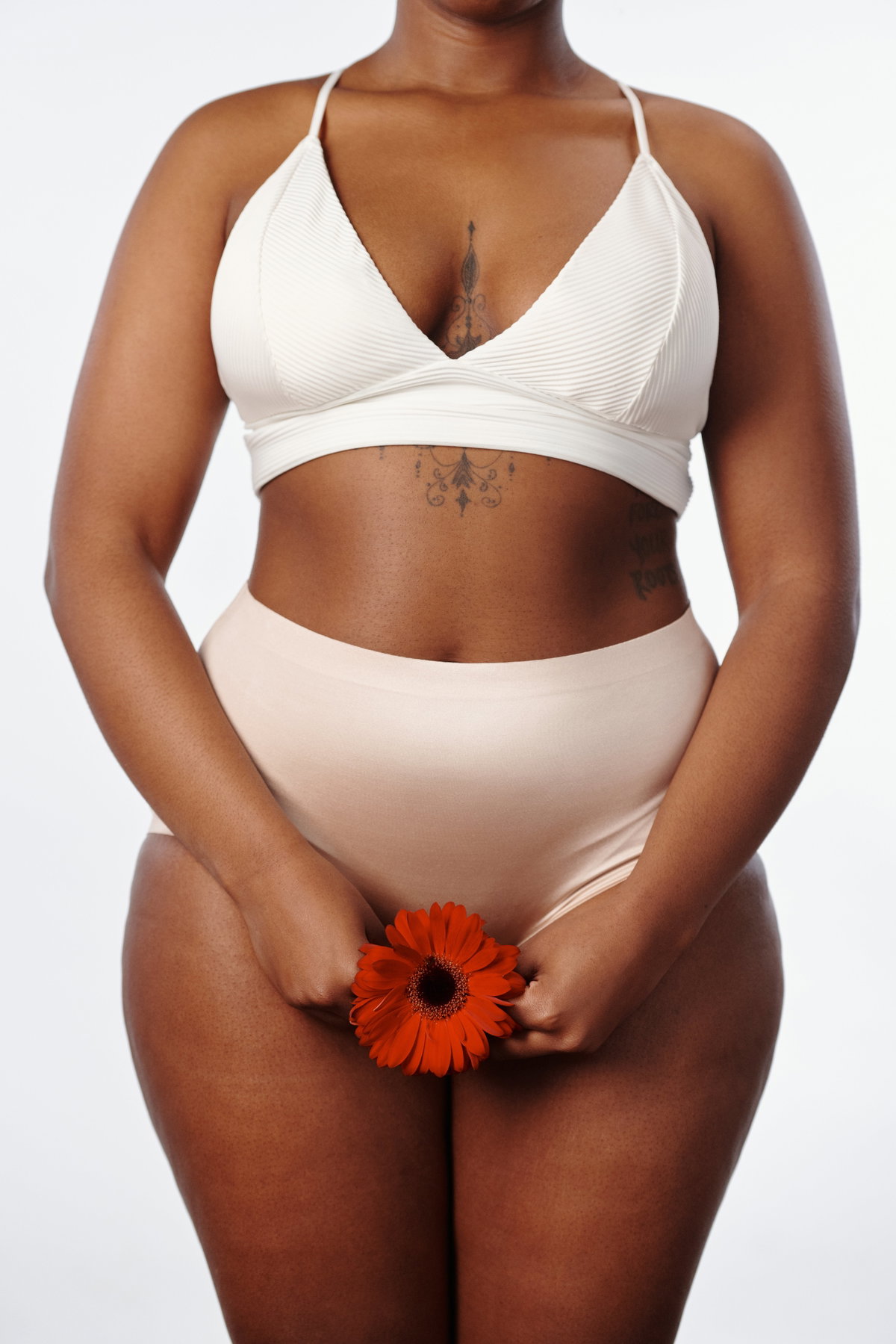 Frau mit Blume vor Intimbereich