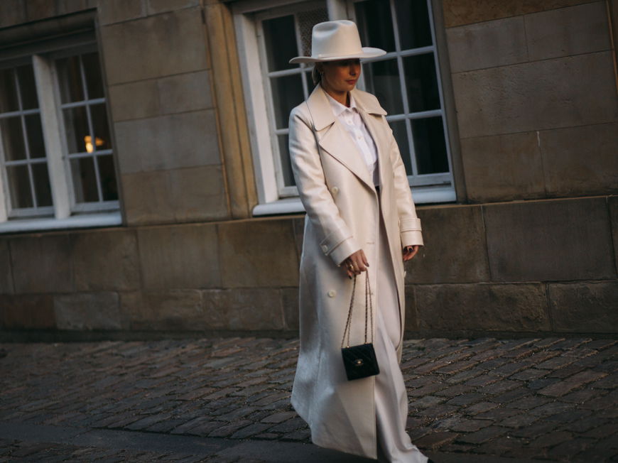 Frau auf Copenhagen Fashion Week trägt cremefarbenen Mantel Streetstyle