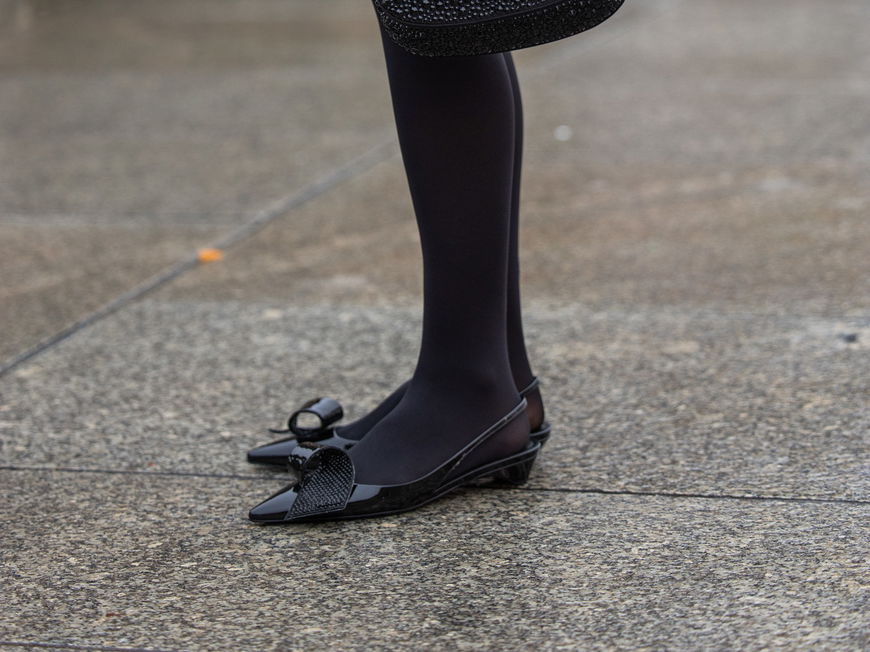 Lea Naumann trägt schwarze Kitten Heels und schwarze Prada Tasche und Strumpfhose Streetstyle