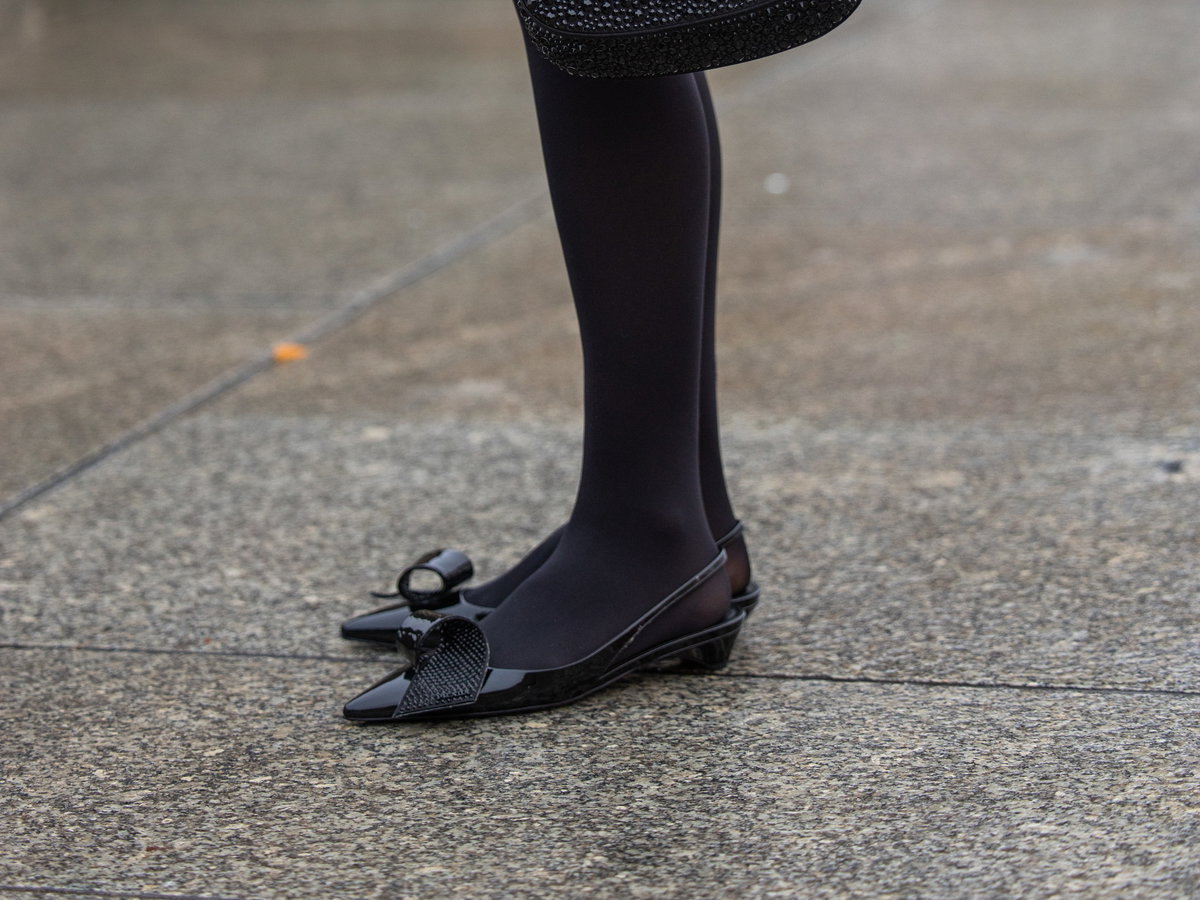Lea Naumann trägt schwarze Kitten Heels und schwarze Prada Tasche und Strumpfhose Streetstyle