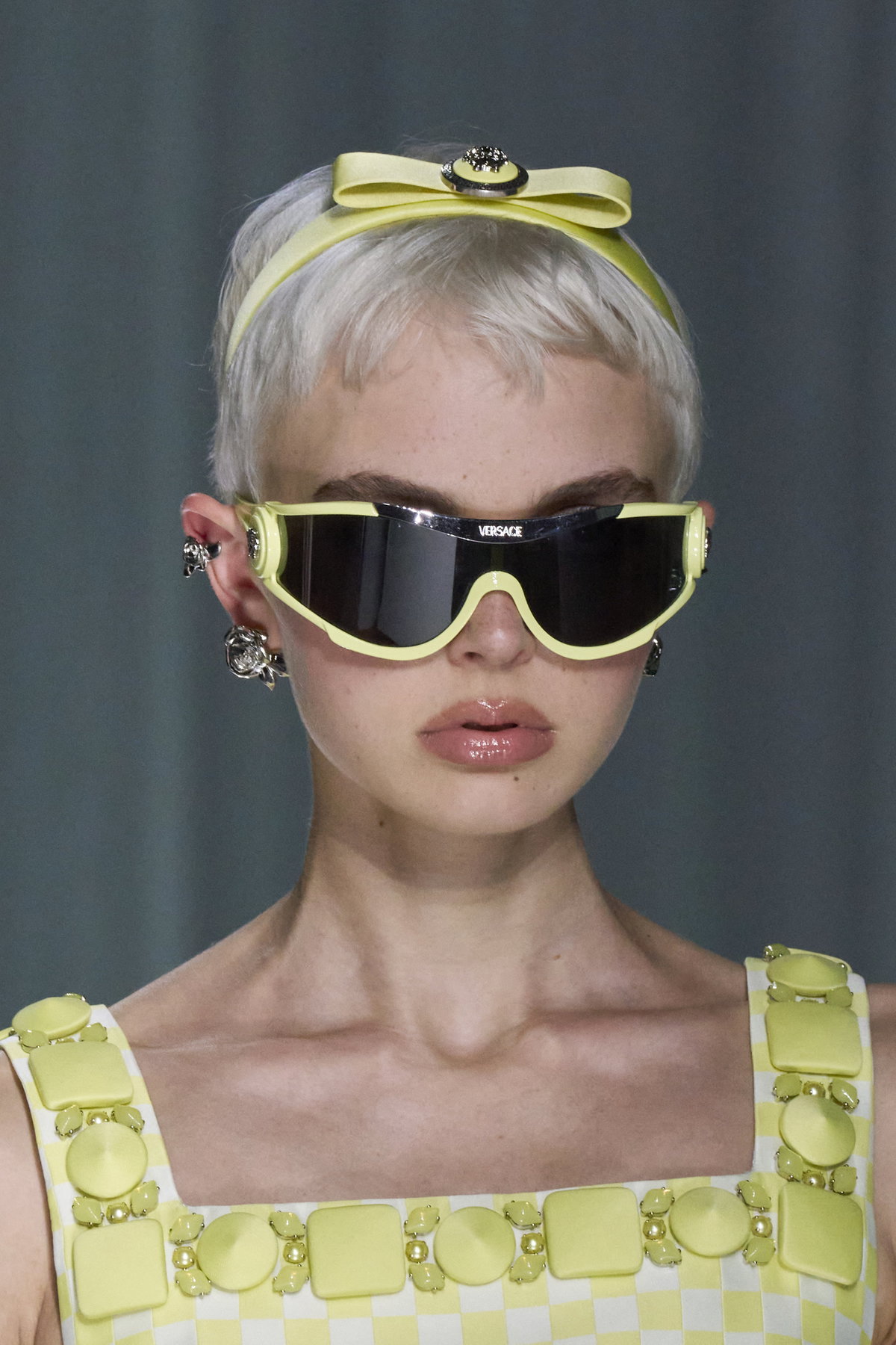 Versace kombiniert die schöne Kurzhaarfrisur zusammen mit einem Haarband.