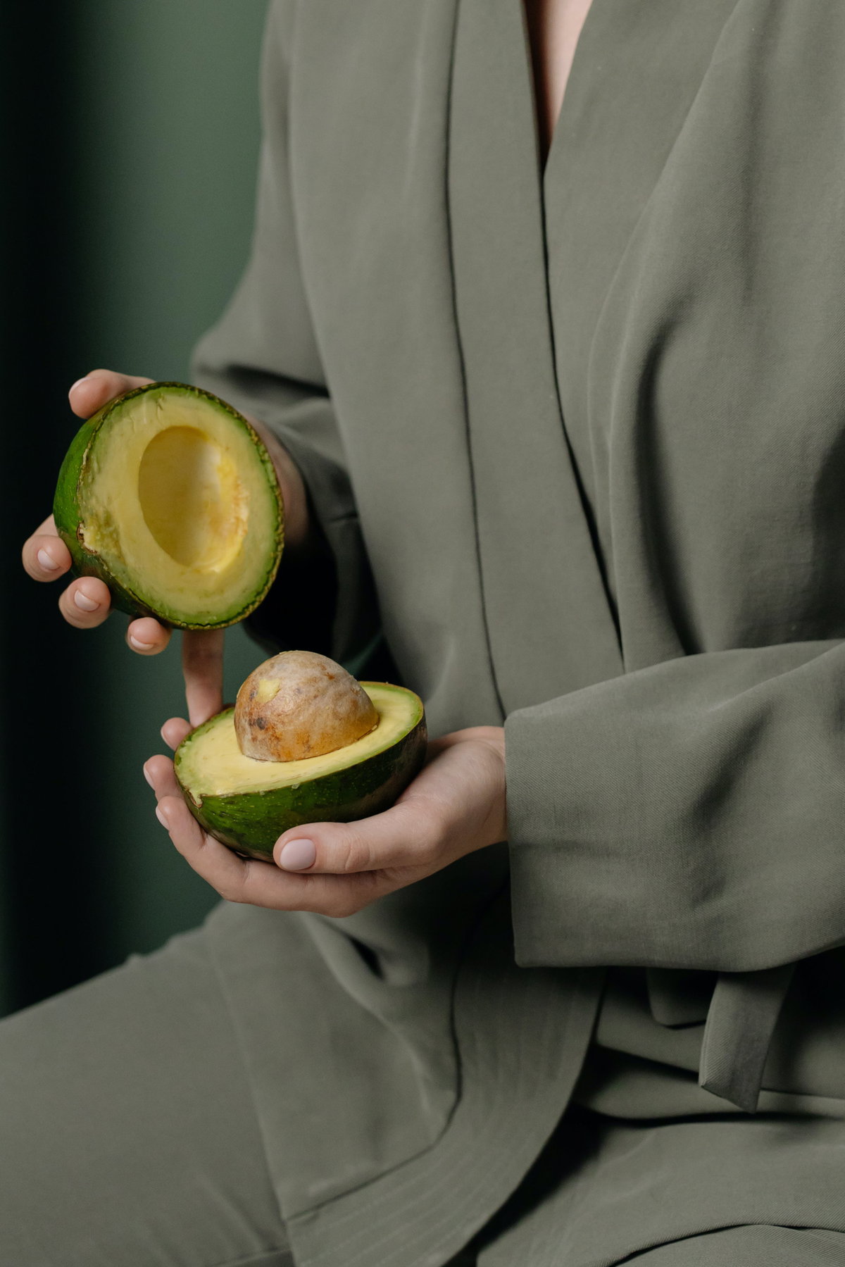 Frau hält eine Avocado in der Hand