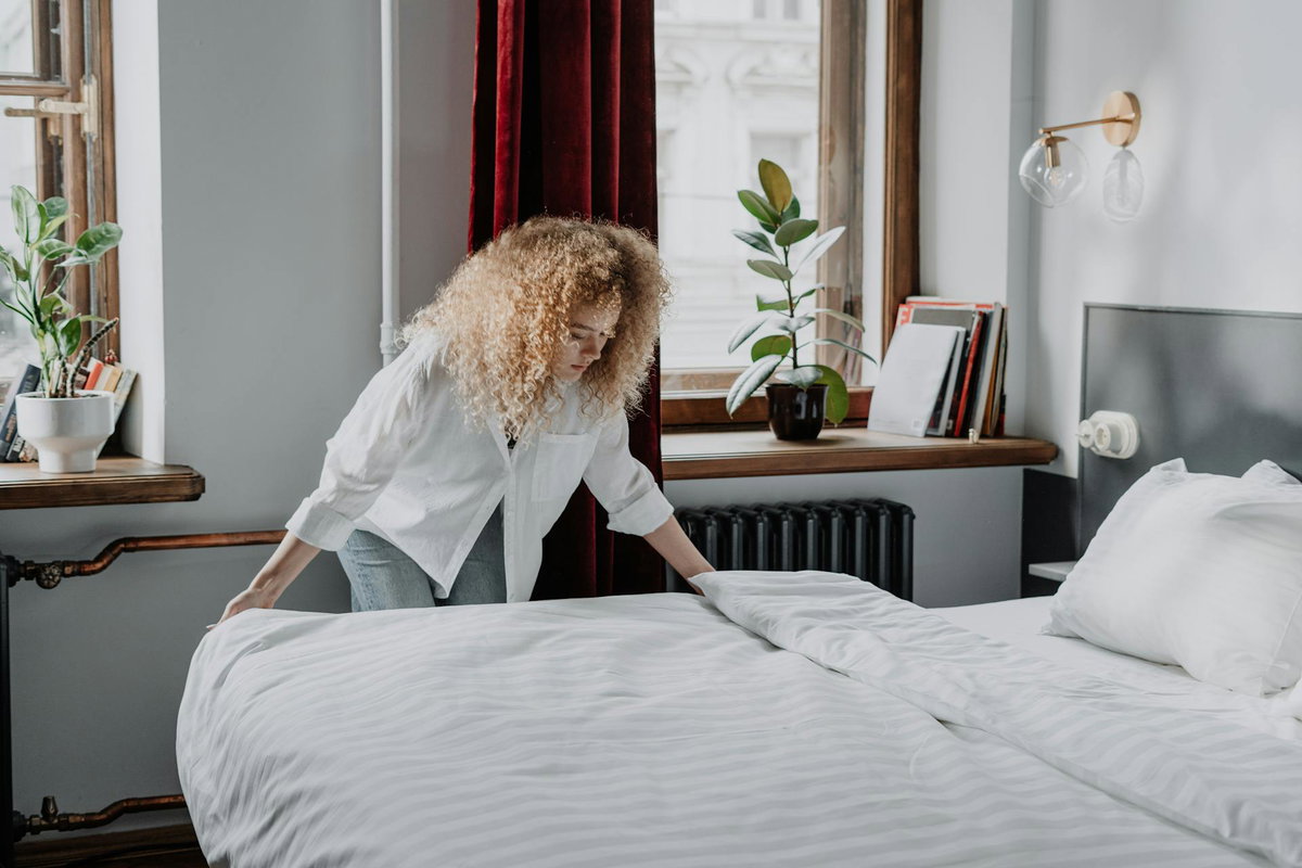 Frau macht das Bett
