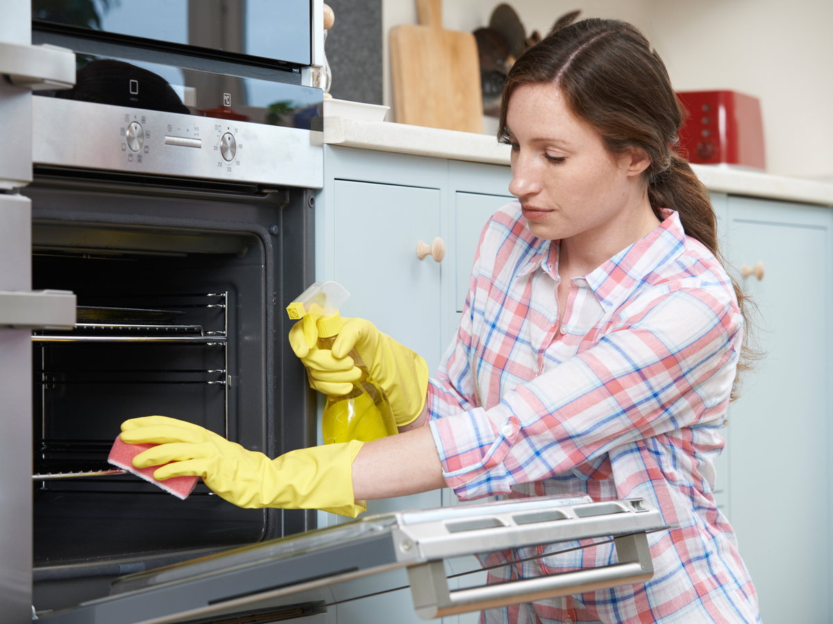 Frau putzt Backofen
