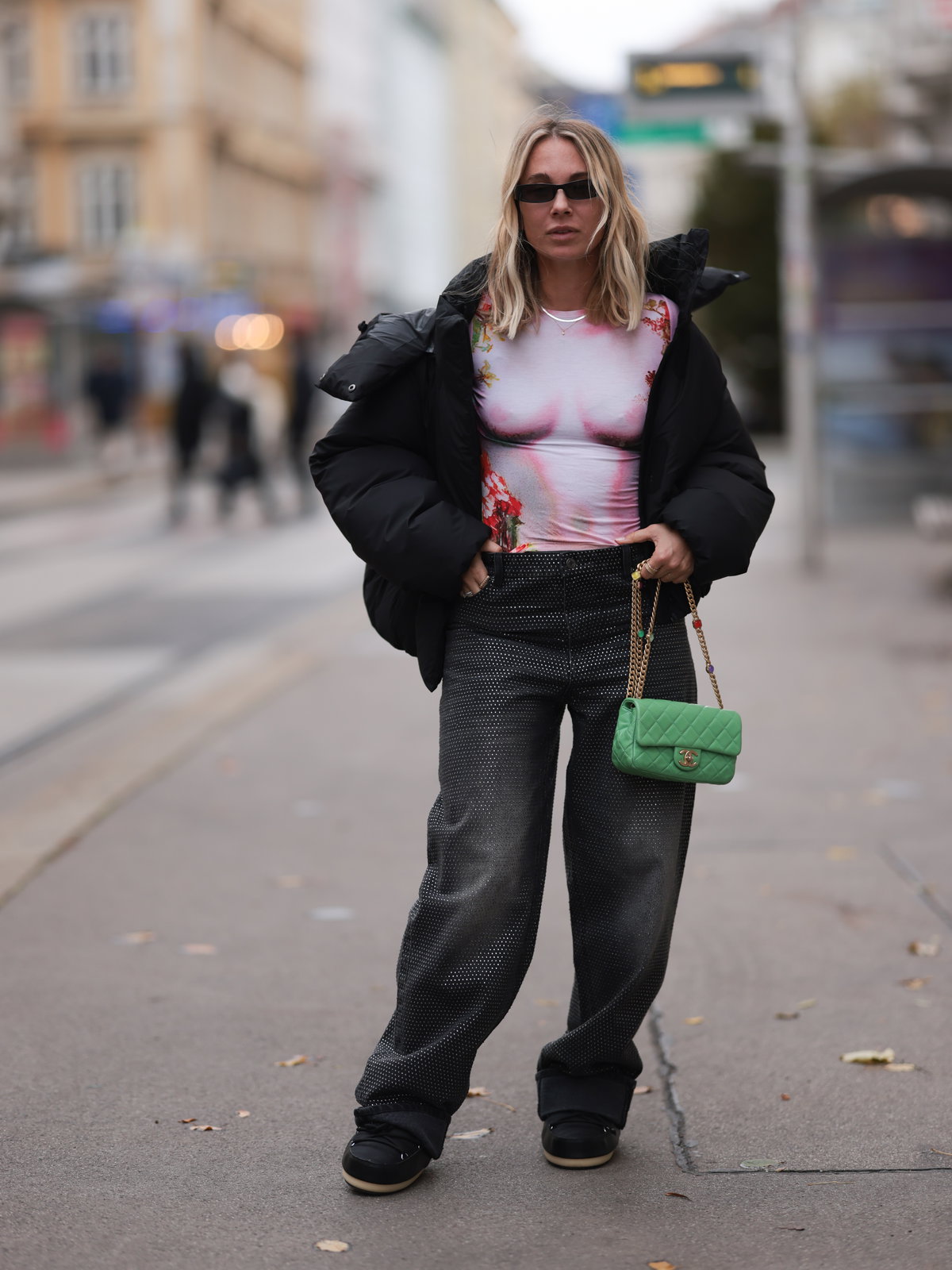 Karin Teigl trägt Wide Leg Jeans schwarze Winterjacke und enges Oberteil