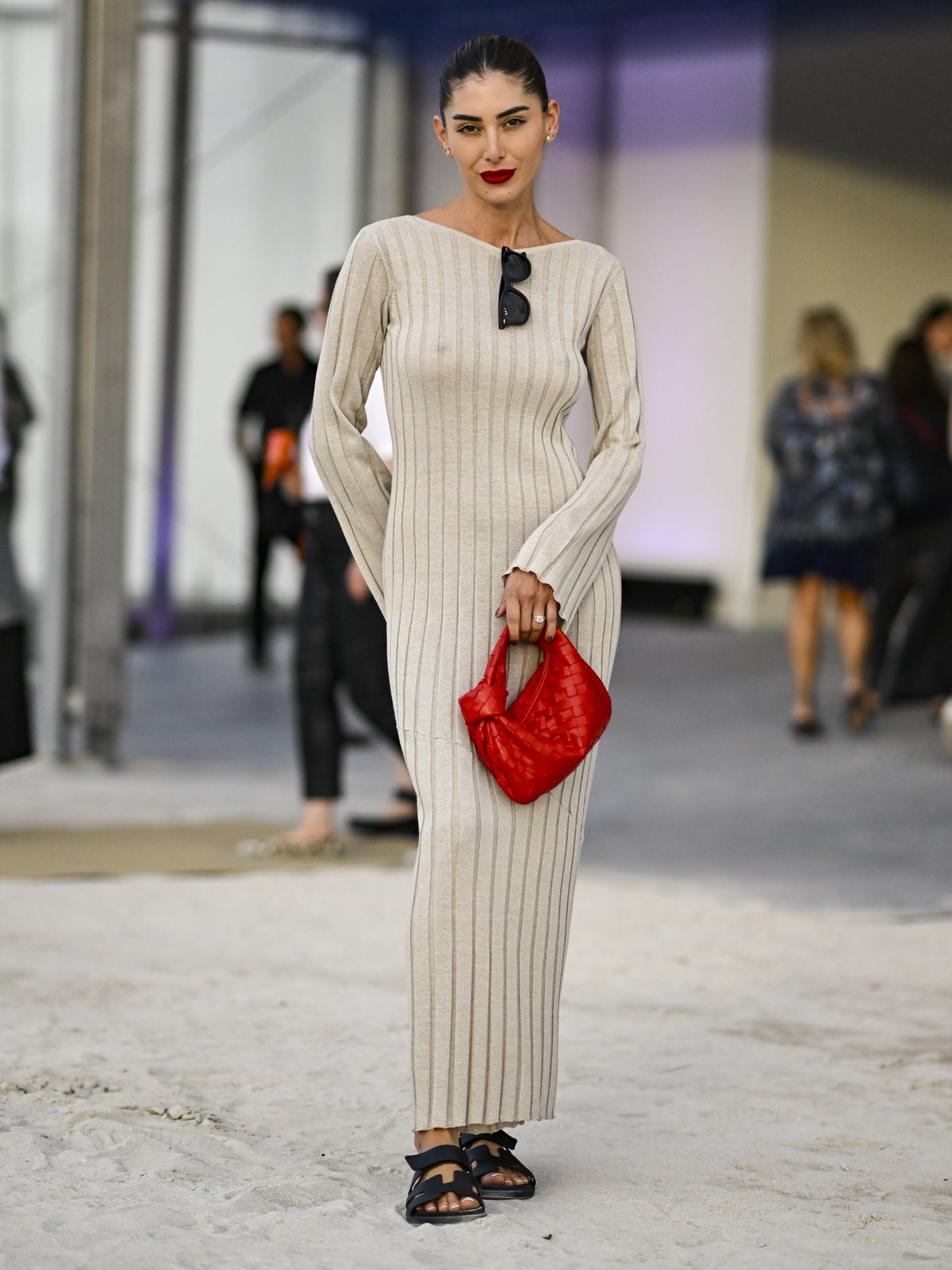 Frau mit einem Strickkleid zu flachen Sandalen