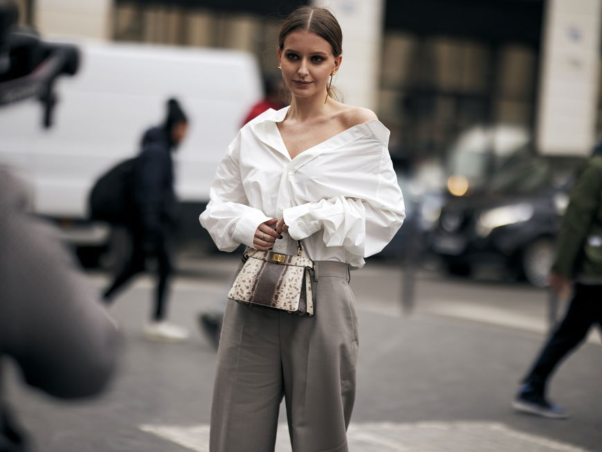 Frau trägt auf Paris Fashion Week weiße Bluse und graue Hose Streetstyle plus Tasche