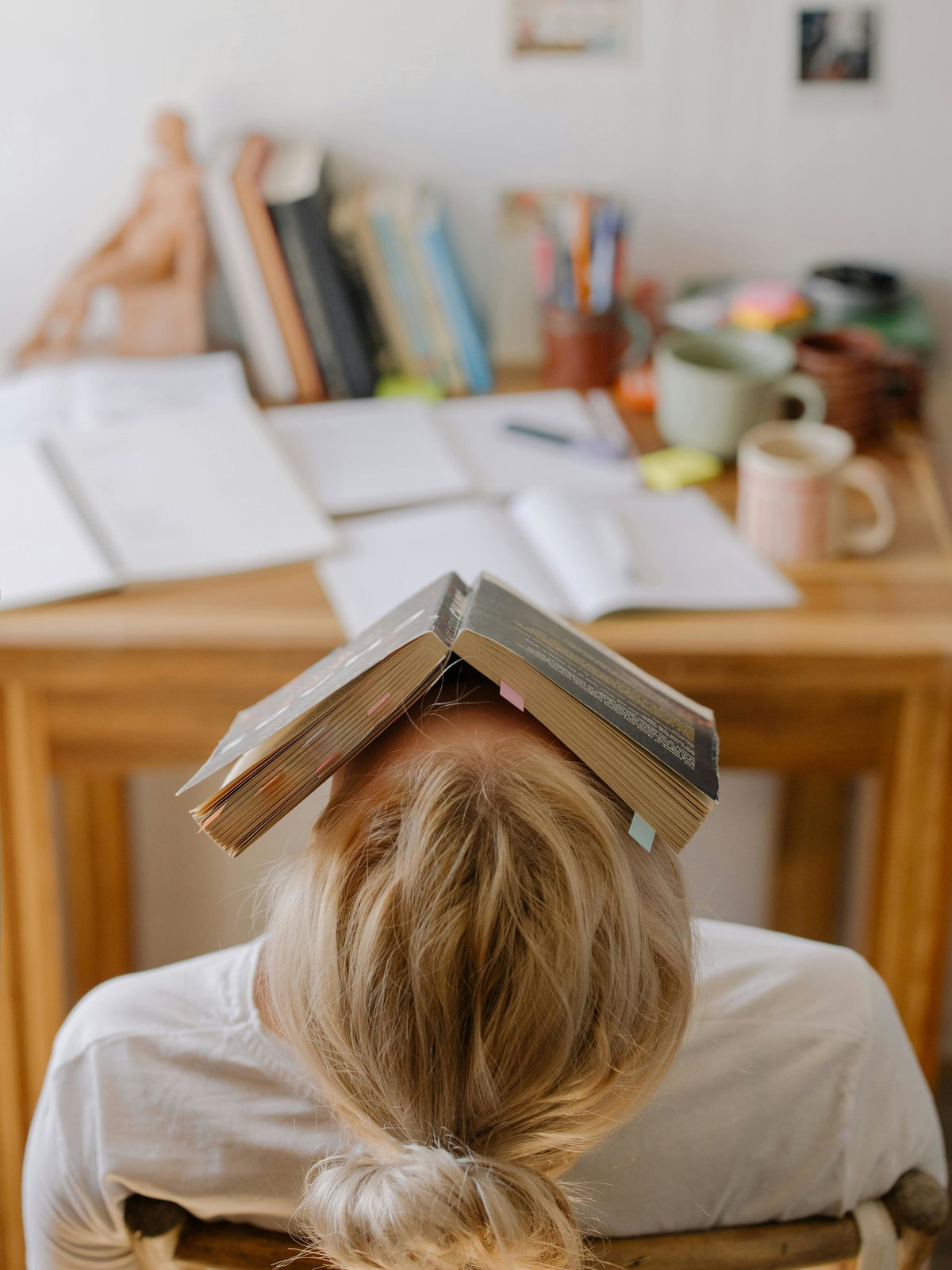 Gestresste Frau mit Buch auf dem Kopf