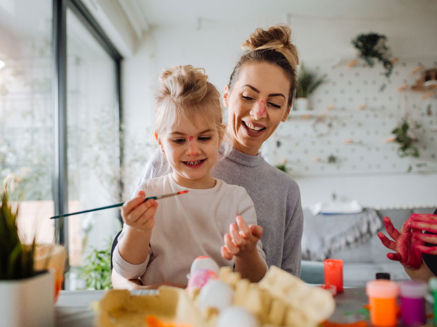 Mutter und Tochter bemalen Ostereier
