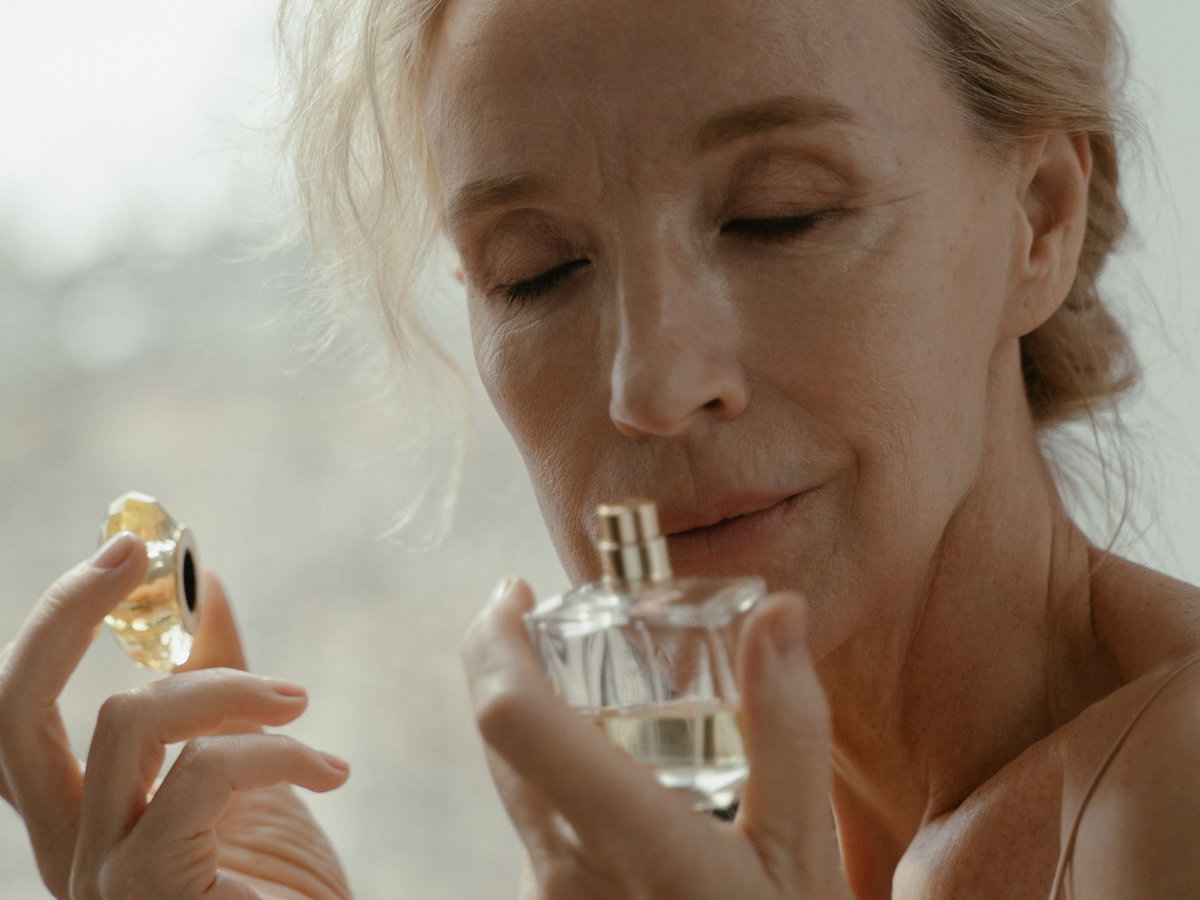 Frau riecht an Parfum