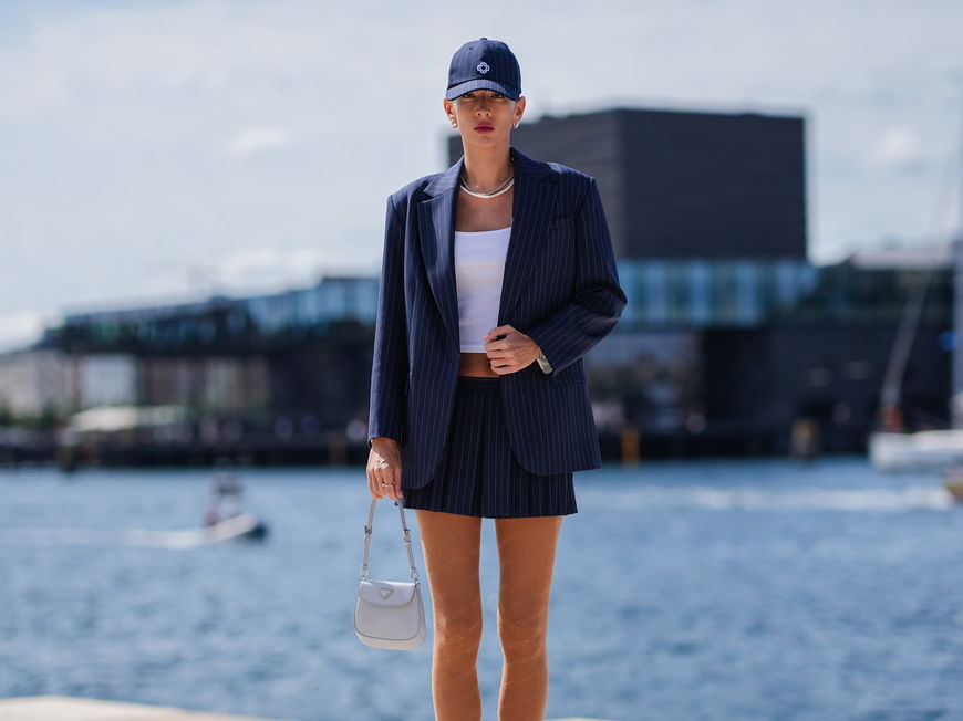 Frau kombiniert blauen Blazer mit Cap